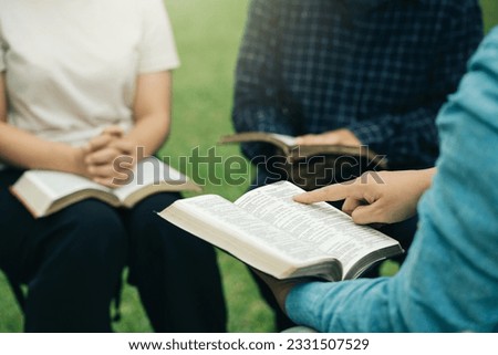 Christian group read and studied the bible at the park and prayed together. sharing the gospel with a friend. Holy Bible study reading together on Sunday. Study the Word Of God With Friends. Education