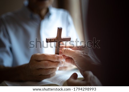 Christian hands of giving cross wood together . Christian good news concept.