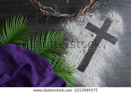 Christian lent background with cross of ashes, palm leaves, crown of thorns and purple cloth