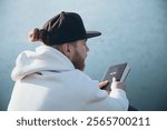 Christian man holds Bible in her hands. Reading the Holy Bible near river during beautiful sunset. Concept for faith, spirituality and religion.