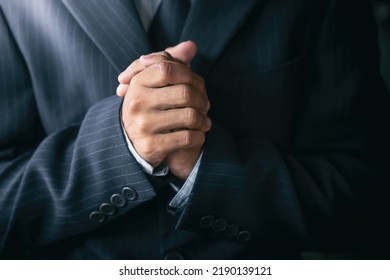 Christian Man In A Suit Praying. Hands Close Up.