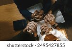 Christian and prayer. Christian group of people holding hands praying worships together to believe and Bible on a wooden table for devotional for prayer meeting concept.