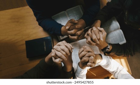 Christian and prayer. Christian group of people holding hands praying worships together to believe and Bible on a wooden table for devotional for prayer meeting concept. - Powered by Shutterstock