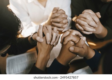 Christian and prayer. Christian group of people holding hands praying worships together to believe and Bible on a wooden table for devotional for prayer meeting concept. - Powered by Shutterstock