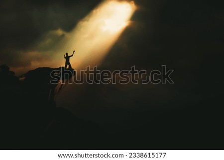 Christian praying to God and man shouting with arms raised to God, pain and trial and sorrow darkness and bright light and rays, hope and despair concept
