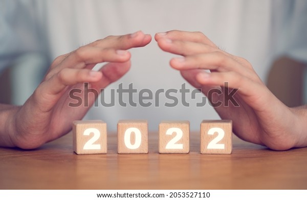 Christian praying for Next year 2022 Happy\
New Year on wooden block.Christian background.Prayer man hand bless\
and pray with faith holy spirit lead protect, Challenge and hope to\
heal people.Pray.