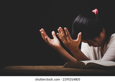 Christian Woman Hand On Holy Bible Are Pray And Worship For Thank God In Church With Black Background, Adult Female Person Are Reading Book, Concept For Faith, Spirituality And Religion