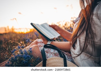 Christian woman holds bible in her hands. Reading the Holy Bible in a field during beautiful sunset. Concept for faith, spirituality and religion. Peace, hope - Shutterstock ID 2185972861