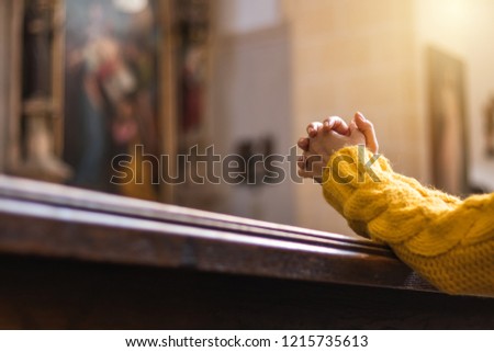 Christian woman is praying with hands crossed in church. Christianity and religious symbol. Belief in Jesus Christ 