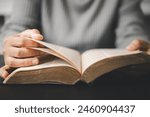 Christian woman reading bible in ancient Catholic temple. Devout Christian woman engages in prayer, fervently reading her Bible against religious background, embodying essence of Catholic devotion.