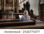 Christian woman is reading bible and praying in church. Religion and spirituality concept. Silent prayer to God