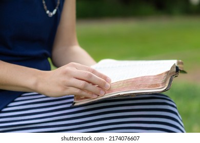 Christian woman sitting outside having quiet time and reading Bible