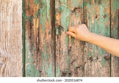 Christian Woman's Hand Knocking On An Old Wooden Door. Seek And Find God And Jesus Christ. Faith, Hope, Love, Obedience, Forgiveness, Mercy, Grace Biblical Concept. Revelation Message. A Closeup.