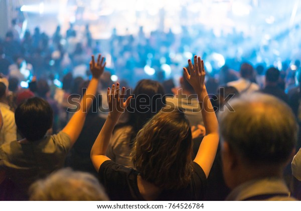 Christian worship with raised hand and pray in\
the worship concert.