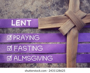 Christianity concept about Ash Wednesday, Good Friday, Lent Season and Holy Week. LENT, PRAYING, FASTING and ALMSGIVING written on purple ribbons. With blurred background. - Powered by Shutterstock