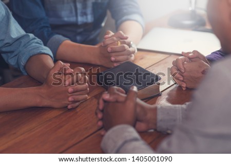 Christians and Bible study concept. Group of discipleship Studying the Word Of God in church and christians holding each others hand praying together