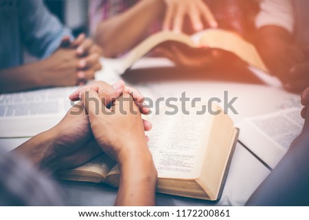 Christians are congregants join hands to pray and seek the blessings of God, the Holy Bible. They were reading the Bible and sharing the gospel with copy space.