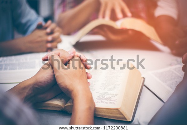 Christians are congregants join hands to\
pray and seek the blessings of God, the Holy Bible. They were\
reading the Bible and sharing the gospel with copy\
space.