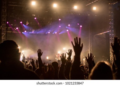 Christians raising their hands in praise and worship at a night music concert