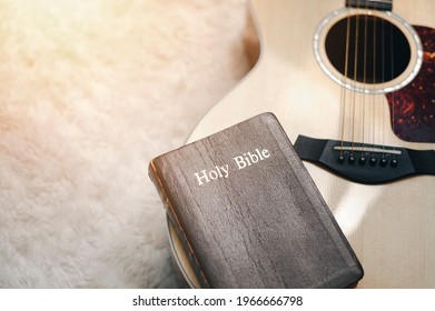 Christians Worship God With A Guitar With The Holy Bible. Reading The Bible And Sharing The Gospel With Copy Space For The Word Of God.