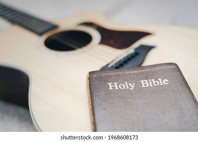 Christians Worship God With A Guitar With The Holy Bible. Reading The Bible And Sharing The Gospel With Copy Space For The Word Of God.