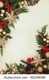 Christmas Abstract Background Border With Gold Snowflake And Bauble Decorations, Holly, Fir And Cedar Cypress Greenery Over Parchment Paper. 