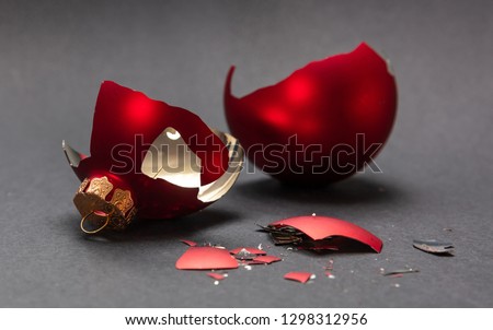 Christmas accident. Red Christmas ball broken, dark gray background, closeup view