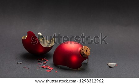 Christmas accident. Red Christmas ball broken, dark gray background, closeup view