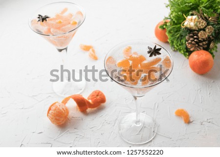 Christmas alcoholic cocktail with tangerines, vodka and star anise, atmospheric New Year's photo with air bubbles