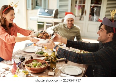 Christmas Is All About Sharing. Cropped Shot Of People Enjoying Christmas Lunch Together.