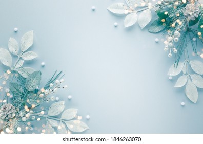 Christmas arrangement with fir branches, silver leaves, pine cones on pastel background. Flat lay. Top view, copy space.