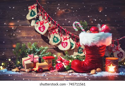 Christmas background. Advent calendar and Santa's shoe with gifts on rustic wooden table - Powered by Shutterstock