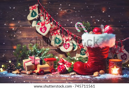 Christmas background. Advent calendar and Santa's shoe with gifts on rustic wooden table