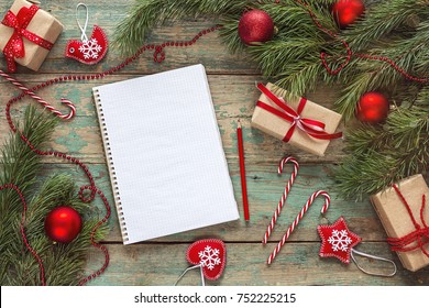 Christmas background with blank notebook, fir branches, decorations and  gift boxes. Space for text. Top view. Christmas to-do list or wish list. - Powered by Shutterstock