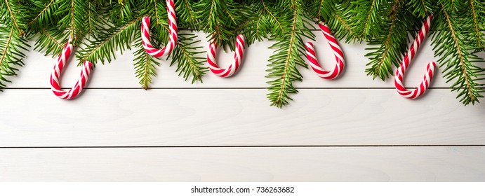 Christmas Background With Candy Canes On White Wooden Table