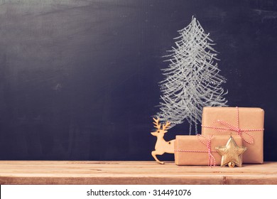 Christmas background with chalkboard and presents.Retro filter effect