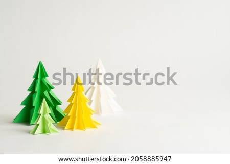 Christmas background, Close up of an origami christmas tree set with variety of color green, yellow, white beautiful arranging on white space. Calendar, Concept, 2022, New year, E-Card, Cover, Mock up