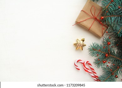 Christmas background. Composition with Christmas gift box, fir tree branch, candy canes and decorations on white background. Top view with copy space. - Powered by Shutterstock