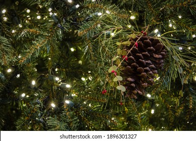 Christmas Background With Copy Space. Pine tree with cone and red berry illuminated by small white rice lights. - Powered by Shutterstock