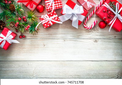 Christmas background with decorations and red gift boxes on wooden board with copy space
