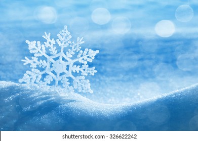 Christmas background with a decorative snowflake on brilliant snow