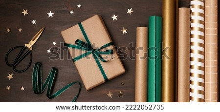 Christmas background with gift boxes and rolls of wrapping paper. Xmas celebration, preparation for winter holidays. Festive mockup, top view, flat lay