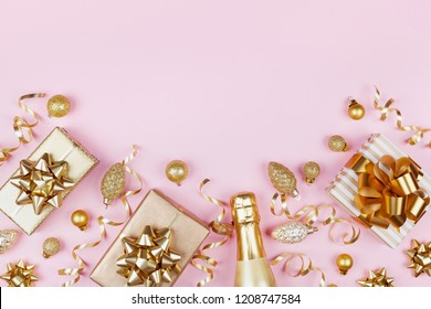 Christmas background with golden gift or present box, champagne and holiday decorations on pink pastel table top view. Greeting card with space for text. Flat lay style. - Powered by Shutterstock