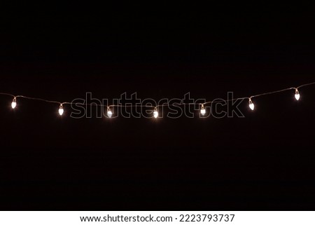 Christmas background with lights and free text space. Christmas lights on black background. New Year and Christmas decor. Garland.
