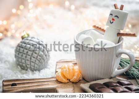 Christmas background with marshmallow snowman in a cup.