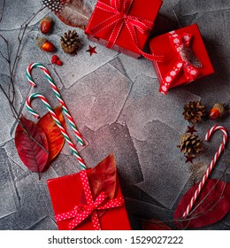 Christmas background with red gift boxes, candy canes, red autumn leaves, stars, feathers and dry twigs. Christmas background. Flat lay, copy space. - Powered by Shutterstock