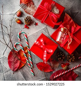 Christmas background with red gift boxes, candy canes, red autumn leaves, stars, feathers and dry twigs. Christmas background. Flat lay, copy space. - Powered by Shutterstock