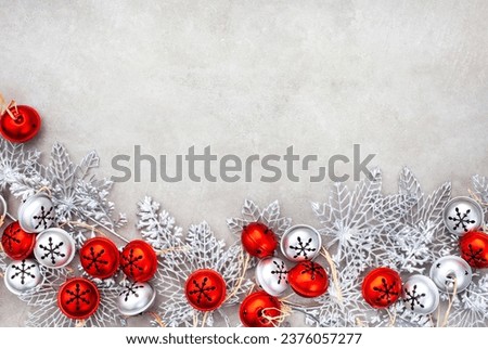 Christmas background of Red and silver rustic jingle bells on grey