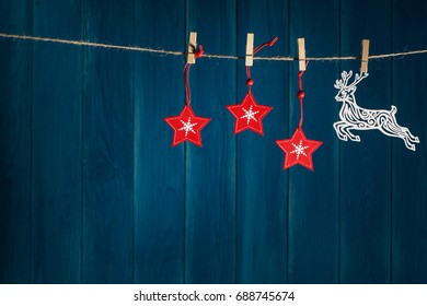 Christmas Background. Reindeer And Red Christmas Stars On Clothespin On Deep Blue Wooden Background With Copy Space. Christmas Or New Year Card Template.