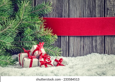 Christmas Background With Small Gifts, Red Ribbon And Spruce Branch